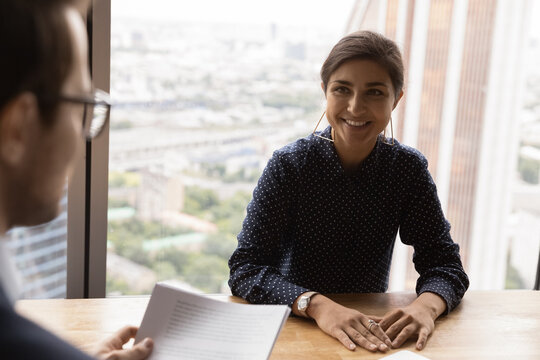 Confident indian lady candidate on vacant place has job interview with hr manager employer recruiter. Smiling young hindu woman hold negotiations discuss contract conditions with male business partner