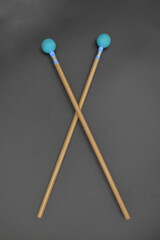 Crossed xylophone
mallets on a black background.