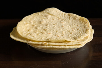 handmade pancakes on a white plate on black background