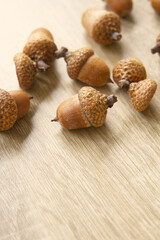 A pile of ripe acorn fruit on wooden table, yellow nut
