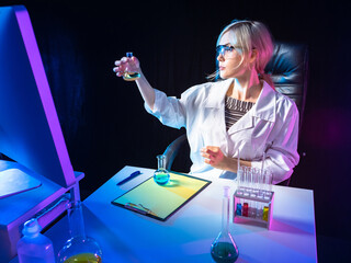 Scientist is engaged in laboratory research. Lab assistant examines test tube. Woman biologist her...