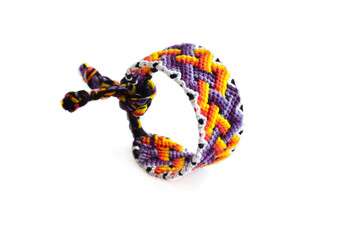 Selective focus of tied woven friendship bracelet with bright colorful pattern handmade of thread isolated on white background