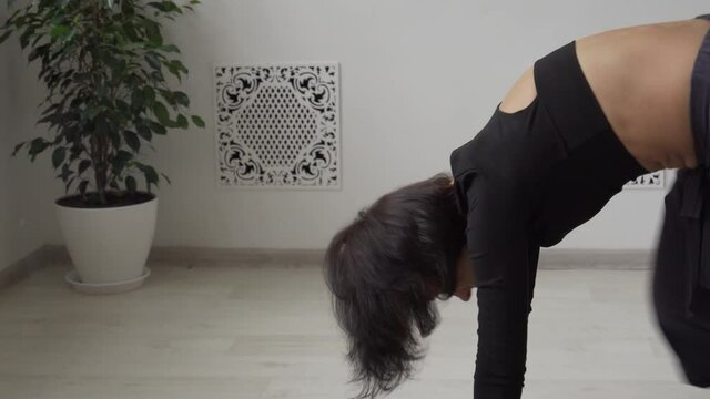 Brunette flexible caucasian girl practice suria namaskar in light yoga studio