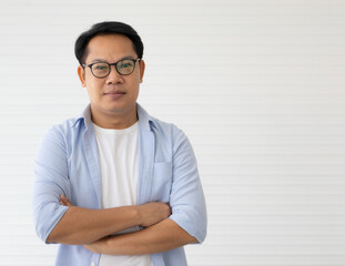 Portrait of Asin man wearing eyeglasses standing fold arms with self-confident and friendly-looking