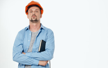 male architect in orange hard hat working gray background cropped view