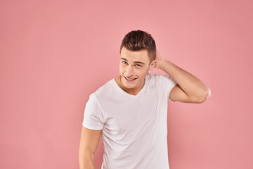 Emotional man gesturing with his hands white t-shirt pink isolated background