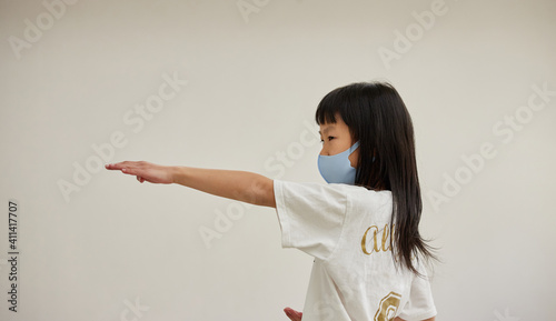 教室でマスクを付けて空手を練習している小学生の女の子の姿 Wall Mural Zheng Qiang