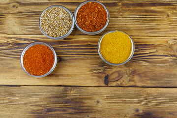 Set of different aromatic spices on wooden table. Top view