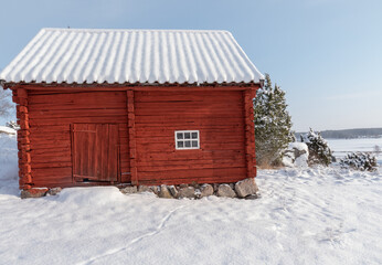 Farm barn and house in a cold winter landscape with snow and frost