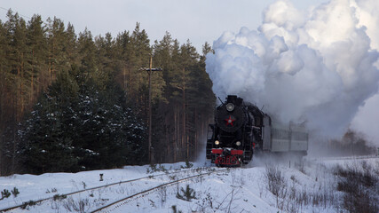 Fototapeta premium Vintage black steam locomotive in Russia in the winter.