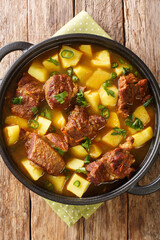 Aloo Gosht Pakistani Beef and Potato Stew closeup in the pan on the table. Vertical top view from above