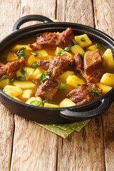 Tasty Aloo Gosht Recipe Mutton Curry with Potato closeup in the pan on the table. Vertical