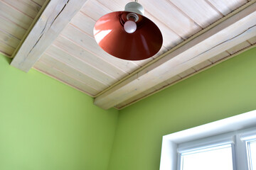 Lamp on the background of a wooden ceiling in a house.
