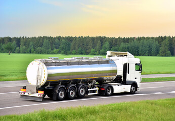 Isothermal Tank truck driving on highway. Oil and Gas Transportation and Logistics. Metal chrome...