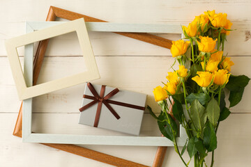 Bunch of yellow rose with wooden frames and a gift box.