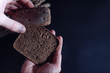 Fresh loaves of bread with wheat and gluten on a black table. Bakery and grocery concept. Fresh, healthy sorts of rye and white loaves food closeup. Fresh homemade bread with cereals.