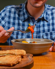 Young man eating salad in restaurant or diner. Georgian cuisine restaurant concept. Vegetable salad with lavash roll.