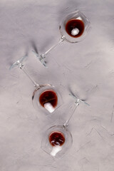 Wine glass laying on a textured background. Close up on with red wine, alcoholic beverage.