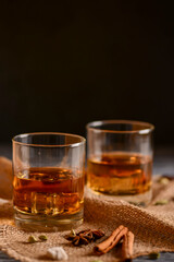 Scotch on wooden background with copyspace. Whiskey in shot glasses. Black background.