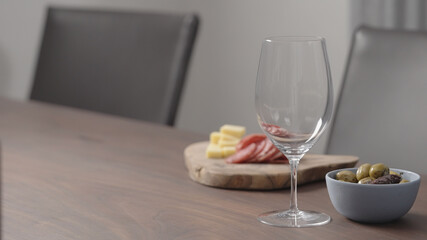 wineglass with appetizers on background on wood table