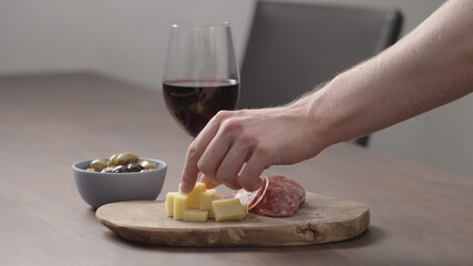 Obraz na płótnie Canvas man hand take appetizers from a table