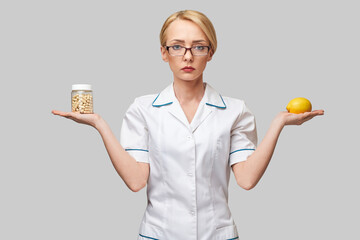 nutritionist doctor healthy lifestyle concept - holding fresh organic lemon fruit and vitamin...