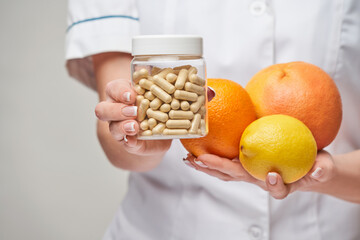 nutritionist doctor healthy lifestyle concept - holding fresh organic citrus fruits - grapefruit,...