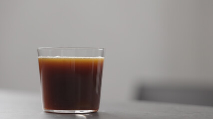 pour coffee in tumbler glass on concrete countertop with copy space