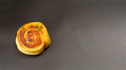 Roll of potatoes on a black background with copy space.