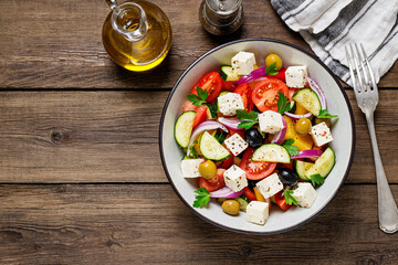 Classic Greek salad with fresh vegetables, feta cheese and  olives. Healthy food. Wooden background. Top view