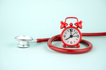 red alarm clock and stethoscope, treatment concept