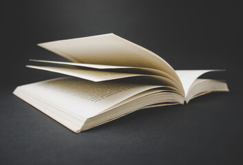 Open book on black background.