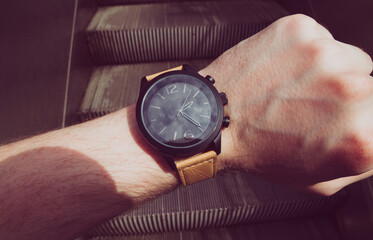 Male looking at his wristwatch on escalator. Point of View (POV).