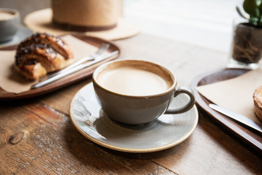 Coffee cup and fresh croissant on table in a coffee shop, Breakfast, travel, food and modern lifestyle concept.