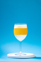 Italian dessert panna cotta with tangerine jelly layer in a glass on blue background