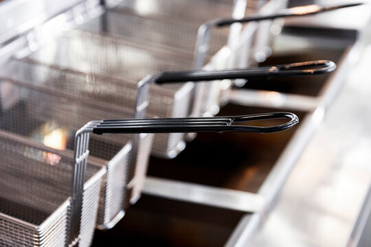 Stainless steel frying baskets in commercial kitchen.