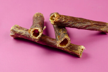 Natural healthy treats for dogs 100% premium quality. Dried beef esophagus, buffalo giblets on a pink background.