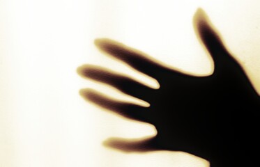 a blurred shadow of a hand on a painted wall, the shadow of a woman's hand