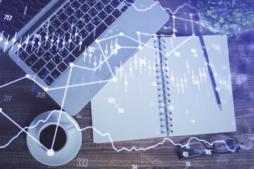 Financial market graph and top view computer on the desktop background. Double exposure. Investment...