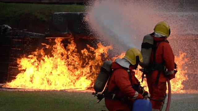 FHD Slow motion: Firefighter using Chemical foam fire extinguisher to fighting with the fire flame from oil tanker truck accident. Firefighter safety disaster accident and public service concept.