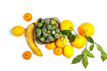 Ripe citrus fruits. Bright fresh fruit composition with foxes on a napkin. Orange, lemon, tangerine, feijoa, banana. Orange, yellow, green colors. Food market.