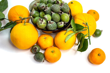 Ripe citrus fruits. Bright fresh fruit composition with foxes on a napkin. Orange, lemon, tangerine, feijoa, banana. Orange, yellow, green colors. Food market.