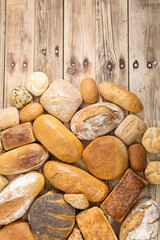 Many kinds and kinds of bread collected in one place on a wooden old shop counter as a decoration for a traditional bakery. View from above.