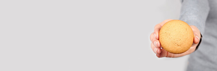 Hand with homemade cookies on grey background.