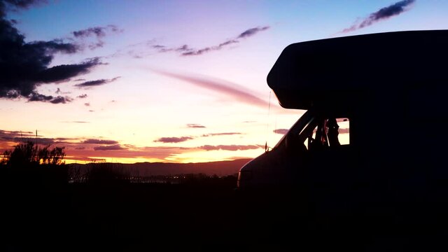 Time lapse of clouds moving over coastal sunset landscape with caravan camping on beach. Capi Corb, Mediterranean coast of Spain.