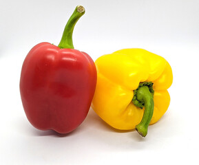 two bell peppers. red and yellow bell peppers on a white background side view