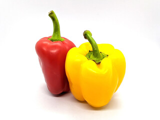 two bell peppers. red and yellow bell peppers on a white background side view