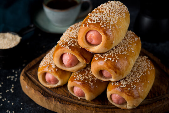 Homemade sausages baked in dough ( pigs in blankets) on a dark background, fast street food