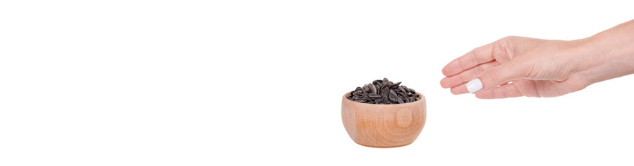 Hand with sunflower seed in wooden jar, isolated on white background.