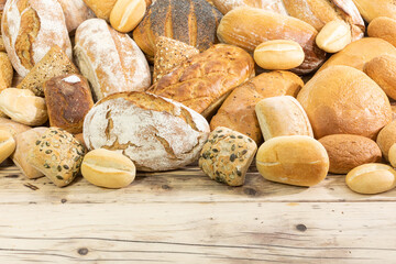 Many kinds and kinds of bread collected in one place on a wooden old shop counter as a decoration for a traditional bakery. White background from the top for self-completion.